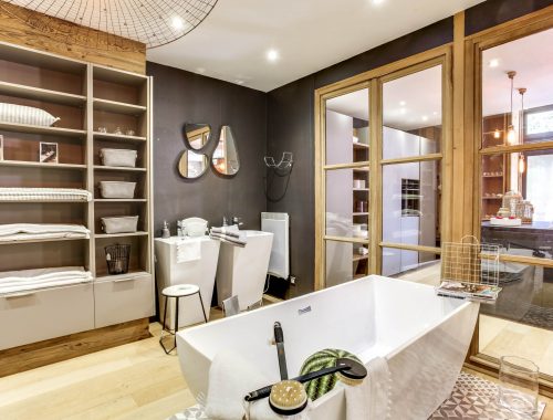 Univers salle de bain chez Bulles Cuisines à Lyon. Salle de bain avec baignoire blanche, dressing et 2 meubles vasques XXL au design contemporain. Jeu de 3 miroirs forme goutte pour un rendu zen et aérien.